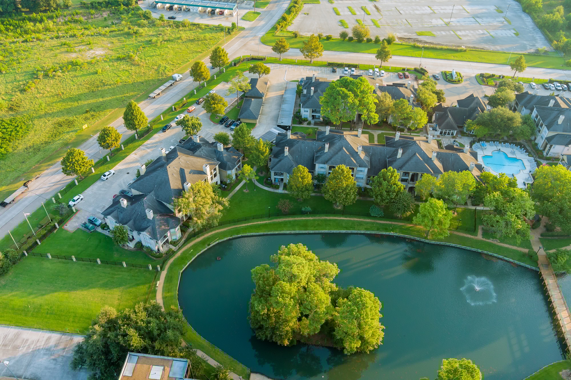 Aerial view of Houston, Texas, US. typical multi-level apartment with pond, surrounded by green gard